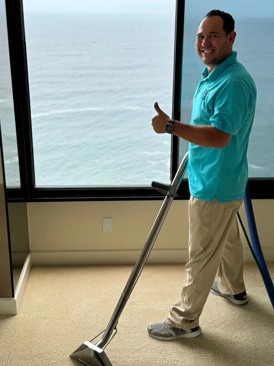 Technician steam cleaning carpet in an ocean-view condo Technician steam cleaning carpet in an ocean-view condo