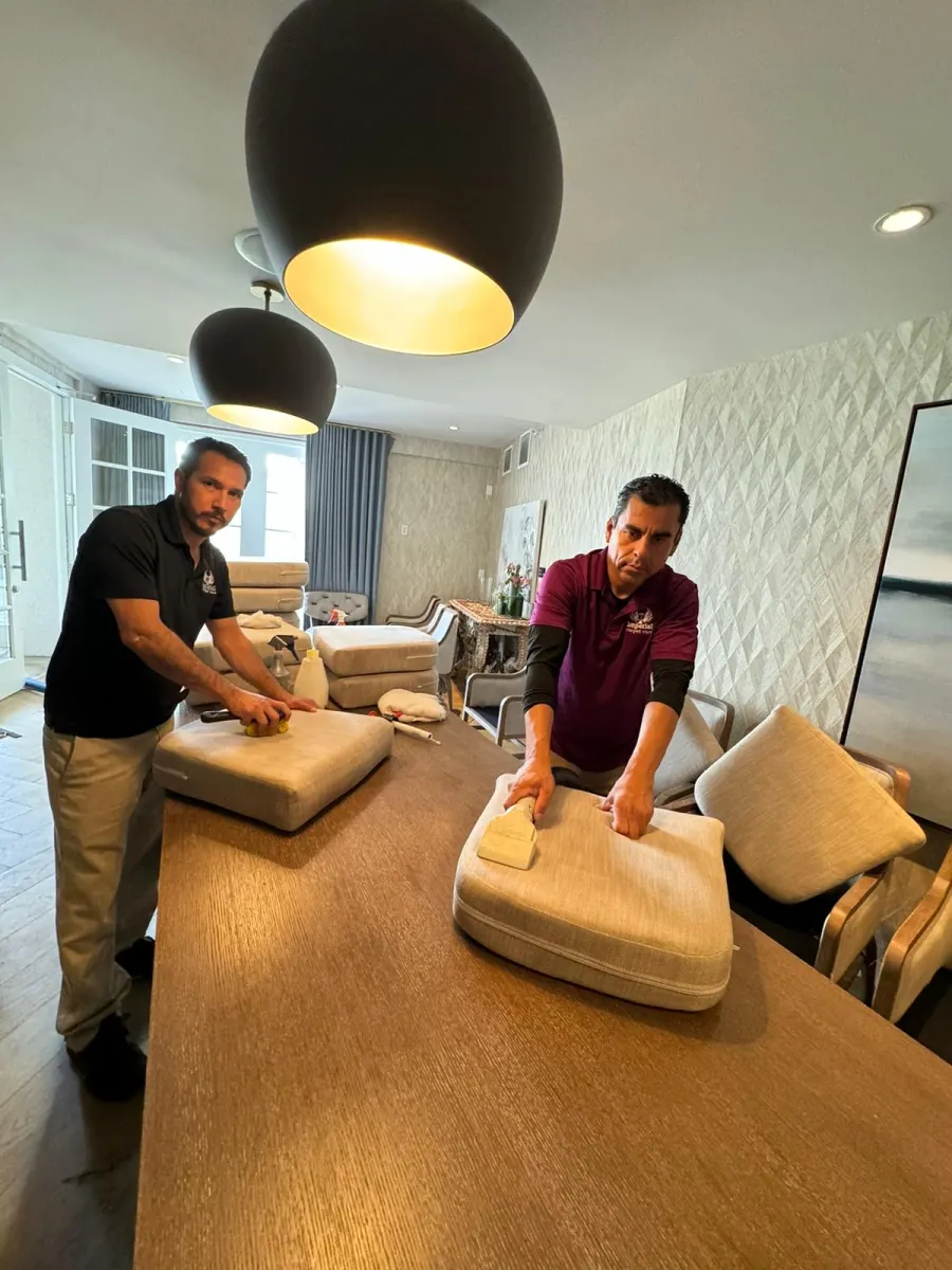 Technicians hand-cleaning sofa cushions on a table Technicians hand-cleaning sofa cushions on a table